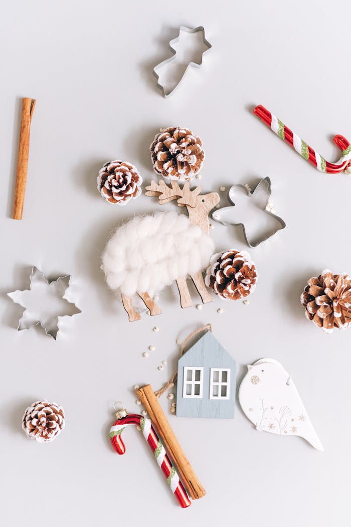 A creative Christmas flat lay featuring ornaments, pinecones, and festive decor on a white background.